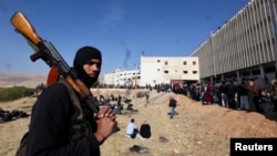 Представитель одного из вооруженных отрядов противников режима Башара Асала наблюдает за поиском заключённых в тюрьме Сейдная, 9 декабря 2024 г.