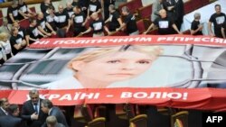Opposition lawmakers roll out a giant poster featuring Yulia Tymoshenko in parliament in Kyiv on September 6. 