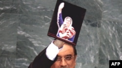 Asif Ali Zardari holds a photo of his slain wife as he speaks at the UN.