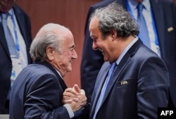 Președintele FIFA, Sepp Blatter (stânga) dă mâna cu președintele UEFA, Michel Platini, pe 29 mai 2015. Cei doi au fost exonerați în luna iulie 2022 de acuzațiile de corupție de către un tribunal elvețian.