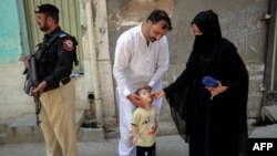 یو روغتیايي کارکوونکی یو ماشوم ته د ګوزڼ واکسیني څاڅکي ورکوي - پخوانی انځور. 