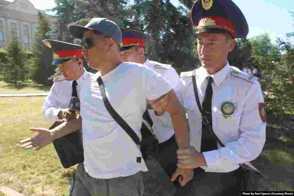 Бұл күні Орал қаласындағы орталық алаңда полиция қызметкерлері Азаттық тілшісі Санат Орын Әлиді ұстап, көлікке салып алып кетті. Оонымен бірге жергілікті "Уральская неделя" газетінің бірнеше журналисін де полиция ұстаған. (Фото авторы - Рауль Упоров.)