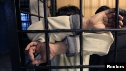 Москванын райондорунун бириндеги убактылуу кармоочу жайдагы мигранттар. 2013-жыл. 