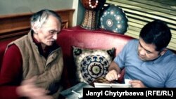 Арстанбек Ирсалиев Чикагодогу кыргыз ресторанда жердеши Нураалы Бекмурзаевге (оңдо) сүрөт көрсөтүүдө