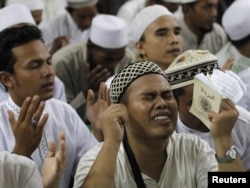 Члены базирующейся в Индонезии группировки «Исламский фронт защитников» совершают молитву в честь лидера экстремистской группировки «Аль Каида» Осамы бин Ладена. Джакарта, 4 мая 2011 года.