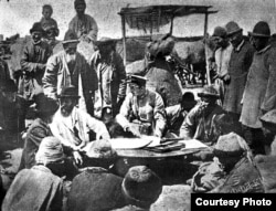 Кыргыздарды келгиндерге берилчү жерлердин планы менен тааныштырууда.