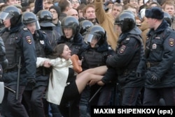 Russian riot police detain a woman during a protest in Moscow on March 26.