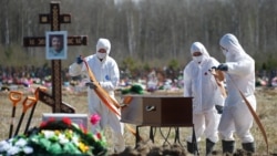Гробари со опрема за лична заштита, погребуваат лице за кое се верува дека починало од ковид-19 во Санкт Петербург претходно оваа година.