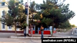 Türkmenabat şäherindäki etrapçalaryň birinde elektrik geçiriji simleri bejerýän ussalar (Illýsutrasiýa suraty)