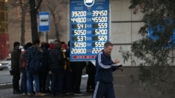 Прохожие на фоне табло с курсами валют. Алматы, 10 марта 2020 года.