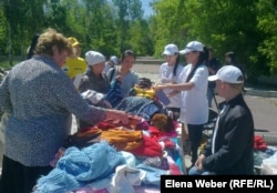 Люди, пришедшие на ярмарку для малоимущих семей, разбирают вещи. Иллюстративное фото. Темиртау, 29 мая 2013 года.