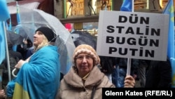 Orsýetiň Krymdaky hereketlerine garşy protest aksiýasynyň gatnaşyjysy "Düýn Stalin şu gün Putin" diýen şygary tutup dur, Stambul, 8-nji mart, 2014.