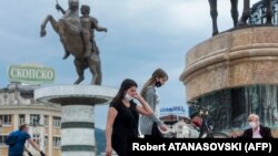 Илустрација: Луѓе со маски на плоштадот Македонија во Скопје