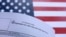 پرچم ایالات متحده در پشت فرم درخواست یکی از انواع روادید ورود به آمریکا 