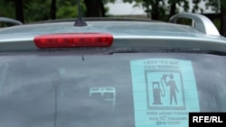 A poster for the protest in a car window