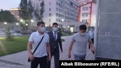 УКМКнын кызматкерлери Азамат Дыйканбаевди (ортодо) Биринчи май райондук сотуна алып келишти. 20.05.2021