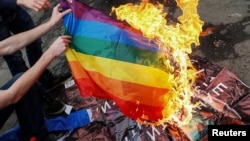 Anti-LGBT protesters burn an LGBT flag during the Kyiv Pride parade in June 2017.