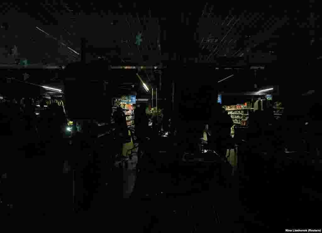 Люди в одному з одеських супермаркетів, що працюють без електрики, під час блекауту в Одесі, 13 грудня 2025 року