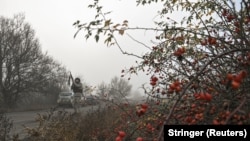 Поліцейський цілиться з гвинтівки під час загрози удару російського FPV на шляху евакуації цивільних із Гуляйполя, Запорізька область, 14 листопада 2025 року