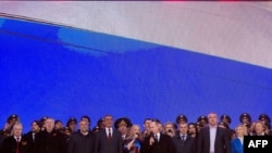Russian President Vladimir Putin (center) and other officials sing the national anthem as they take part in a rally and concert by the Kremlin Wall in central Moscow on March 18.