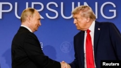 აშშ-ის და რუსეთის პრეზიდენტები ტრამპი და პუტინი ერთმანეთს ხელს ართმევენ 15 აგვისტოს, ალასკის შტატის ქალაქ ანკორიჯში უკრაინაში ომის განსახილველად გამართული შეხვედრის შემდეგ.