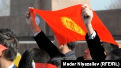 Мужчина держит флаг Кыргызстана на центральной площади Оша.