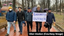 Камактагы активист Тилекмат Кудайберген уулунун атасы Кудайберген Куренов плакат көтөрүп келатат. "Мыйзамдуулук үчүн!" тынчтык жүрүшү учурунда тартылган сүрөт.