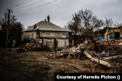 Eddy (lent balra) és társai egy donyecki településen javítanak egy, a háborúban megrongálódott háztetőt 2024. november 6-án