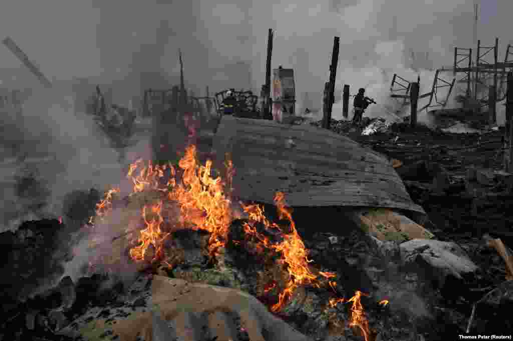 Службы экстренного реагирования работают на месте склада, который был поражен в ходе ночной атаки российских ракет и дронов, Новые Петровцы, недалеко от Киева, Украина, 6 декабря 2025 года. REUTERS/Thomas Peter 