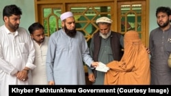 صوبايي وزير ډاکټر امجد علي يوې ښځې ته د پیسو چيک ورکوي 