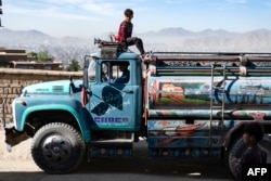Un băiat pe cabina unui camion-cisternă la Kabul, pe 27 aprilie 2025.