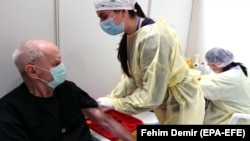 Пациент прима вакцина за време на почетокот на масовната вакцинација во центарот во Олимписката сала „Хуан Антонио Самаранч“ во Сараево, 21 април 2021 година