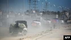 کامیون‌های حامل کمک‌های «برنامه جهانی غذا» در جاده‌ای در دیر البلح در مرکز نوار غزه
