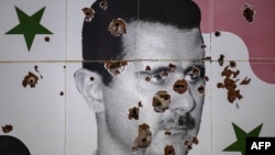 Бийликтен кулатылган мурдагы президент Башар Асаддын сүрөтүнө атылган октор.