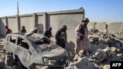 Ооганстан менен Пакистандын ортосундагы чек арадагы кагылышуулардан кийин. Кандагар провинциясынын Спин-Болдак районунда талибдердин коопсуздук кызматкерлери талкаланган автоунаанын жанынан өтүп бара жатат.