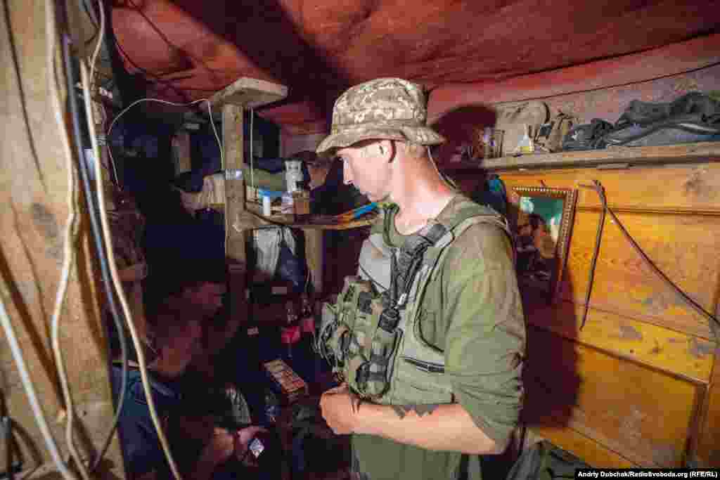 Позиції &ndash; це вкопані в землі спостережні та вогневі точки у полі, що з'єднані між собою лініями окопів. Вони оточують майже все село. Живуть військові, у глибоких бліндажах. Місця небагато, але це досить надійний захист від артобстрілів, що тут відбуваються часто. На фото &ndash; матрос із позивним &laquo;Нік&raquo; в одному зі &laquo;спальних&raquo; бліндажів морпіхів