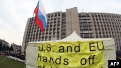 Orsýete tarapdar separatistler tarapyndan eýelenen hökümet binasynyň öňünde "ABŞ we ÝB Ukrainadan el çekiň" ýazgyly plakat, Donetsk, 10-njy aprel, 2014. 