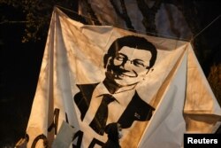 Человек проходит мимо баннера с изображением Экрема Имамоглу во время акции протеста против его задержания в Стамбуле 20 марта