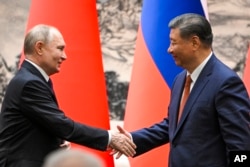 Голова Китаю Сі Цзіньпін тисне руку очільнику Росії Володимиру Путіну під час зустрічі у Пекіні в травні 2024 року