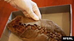A researcher holds the ancient shoe at the Armenian Institute of Archaeology and Ethnography.