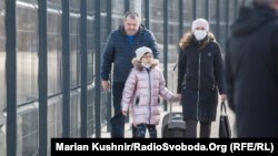 Жена и нејзината ќерка минуваат преку административниот граничен контролен пункт кај Станица Луханска, одвојувајќи го градот Луганск, контролиран од сепаратистите, од територијата контролирана од владата во источна Украина, на 20 февруари.