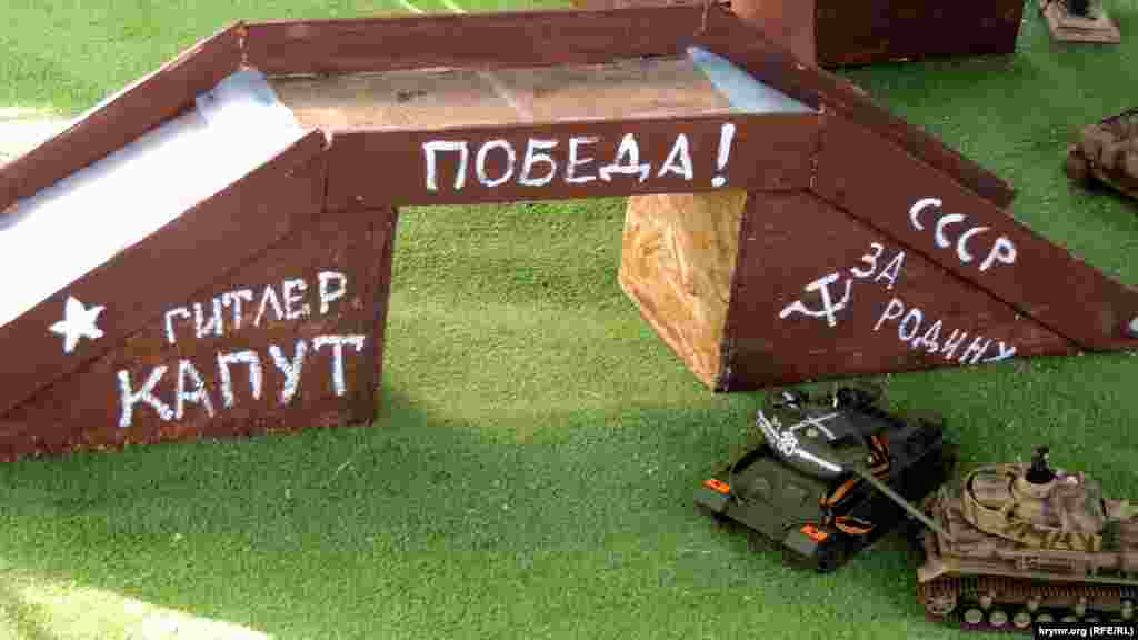 На іграшкових танках зав'язані георгіївські стрічки, написи на атракціоні говорять: &laquo;Гітлер капут&raquo;, &laquo;СРСР&raquo;, &laquo;Перемога!&raquo;, &laquo;За Батьківщину&raquo;