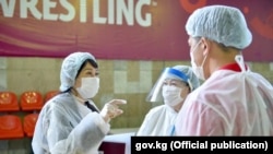 Экс-вице-премьер министр Аида Исмаилова спорт залга жайгаштырылган стационардын дарыгерлери менен. Август, 2020-жыл.