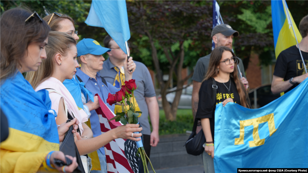 Washingtonda Kommunizm qurbanlarınıñ abidesi yanında qırımtatar genotsidiniñ qurbanlarını añma merasiminde qırımtatar bayrağı, 2025 senesi mayısnıñ 18-i