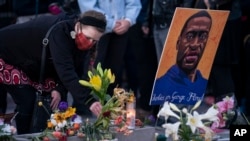 Flori în amintirea lui George Floyd și mesajul „Justiție pentru George Floyd" la una dintre demonstrațiile la care a fost celebrat verdictul. Minneapolis, 20 aprilie 2021