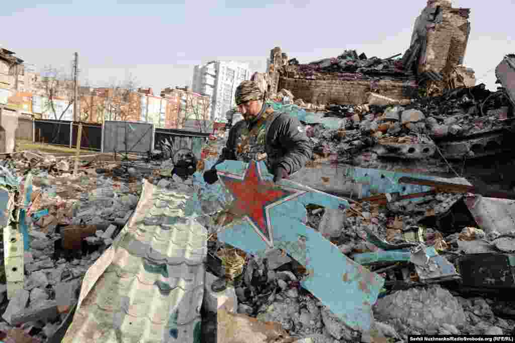 Доброволець ТрО Чернігова тримає фрагмент російського винищувача, збитого над містом силами української ППО. Квітень 2022 року