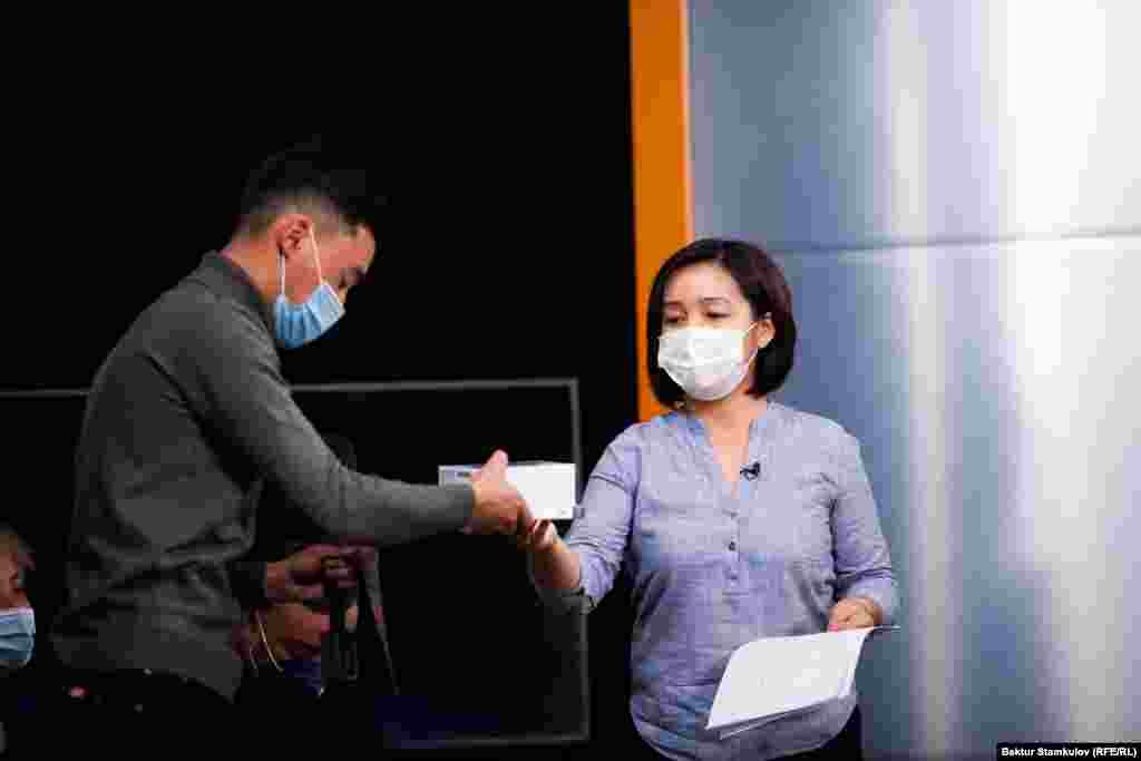 Сынакка алгачкылардан болуп баян жөнөткөндөрдүн бири - Адил Какеновго "Азаттыктын" Бишкектеги кеңсесинин директору Айзада Касмалиева белек тапшырууда.