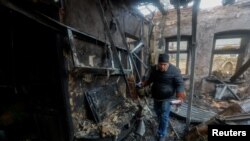 Урандылардын арасынан буюмдарды чогултуп жүргөн тургун. Донбасс аймагынан тартылган сүрөт.