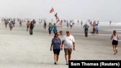 Жэксонвилл пляжында эс алып жаткан адамдар.  Флорида, АКШ. Июнь, 2020-жыл.