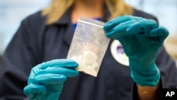 Un ofițer prezintă o cantitate de fentanil confiscată în urma unui raid al Drug Enforcement Administration (DEA) în Stirling, Virginia, la 9 august 2016.